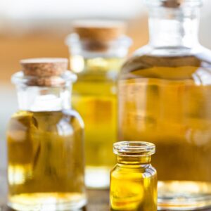 Assortment of pure organic essential oils in glass bottles on wooden table